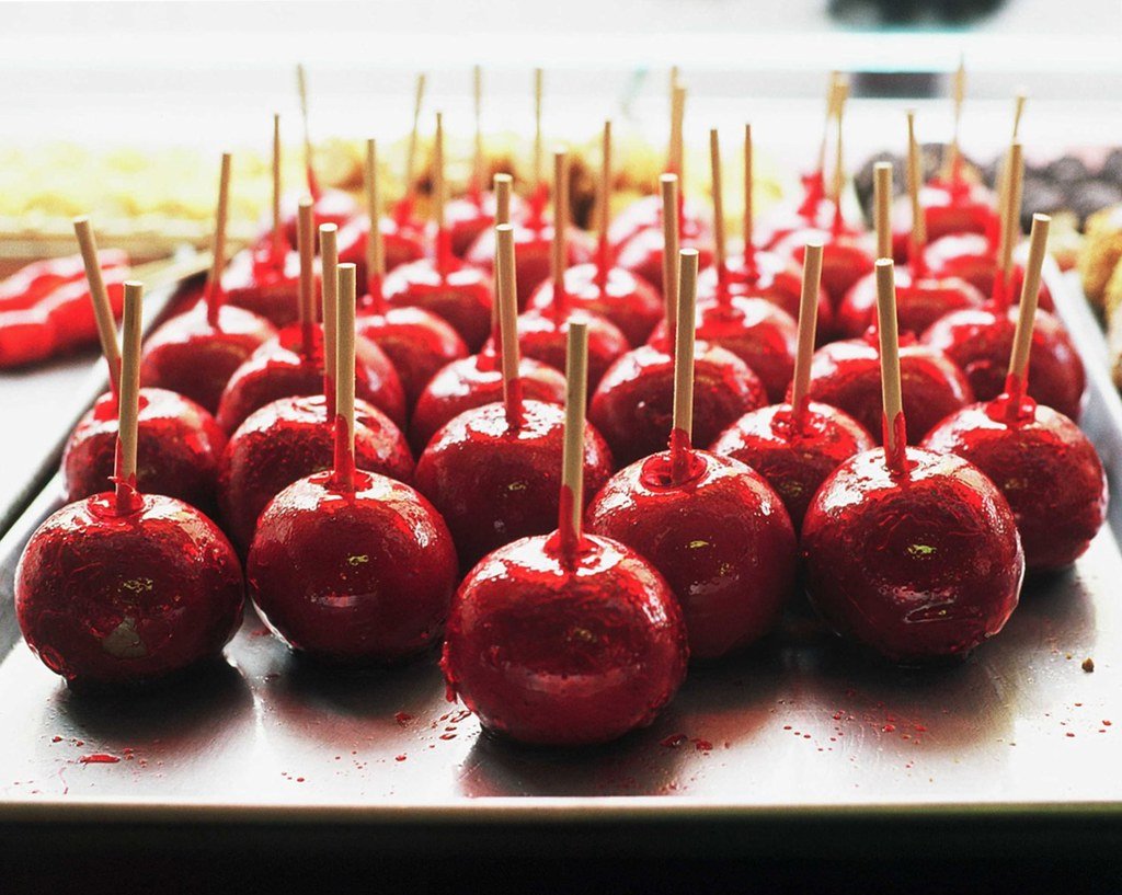 Rows of glossy red candy apples on sticks at Williams Candy Shop in Coney Island.